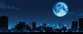A cityscape at night with a large blue moon in the sky. Royalty Free Stock Photo