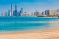 Cityscape panorama of Abu Dhabi downtown with sea, sand beach and skyscrapers. Sunny summer day in Abu Dhabi. Famous tourist