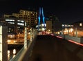 cityscape with the pedestrian footbridge crossing the river aire in leeds at night with bright lights and illuminated waterside