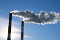 Cityscape with pipes of thermal power plant, against a blue sky background. Ecology problems. Pollution Royalty Free Stock Photo