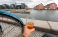 Cityscape with riberboat, old buildings and relaxed visitor of Copenhagen with beer in hand, Denmark. Danish capital