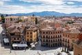Cityscape of Segovia, Spain, with narrow stone streets, restaurants, medieval architecture.