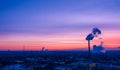 Cityscape with silhouette of  heating plant and pipe with steam against sunset Royalty Free Stock Photo