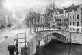 Cityscape on a sunny winter day, in black-and-white color - view of the bridge and canal in the historic center of Amsterdam