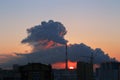 Cityscape at sunrise with smoking pipe