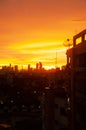 Cityscape by sunset, top view of urban area at dusk, fantastic colors of sky, satellite dish on the roof of residential building