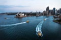 Cityscape of Sydney with Opera house and ferry boats in the ocean after sunset, Sydney, Australia