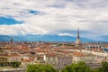 Cityscape of Torino Turin, Italy with the Mole Antonelliana towering over the buildings. Wind storm clouds over the Alps in the