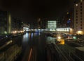 Cityscape view of clarence dock in leeds at night showing the lock gates and water surrounded by buildings Royalty Free Stock Photo
