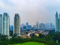 A cityscape view in Kuningan, Jakarta with tall buildings and lush trees in the foreground. Royalty Free Stock Photo