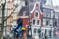 Cityscape - view on the old houses of Amsterdam and cyclist in the rain through motorcycle windshield Royalty Free Stock Photo