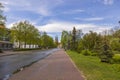 Cityscape view of road with green trees on sides and famous church towers on background. Royalty Free Stock Photo