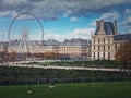 Cityscape view to the Grande Roue de Paris ferris wheel next to Louvre museum building and parisian houses, France Royalty Free Stock Photo