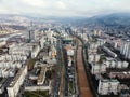 Cityscape view of an urban area with a wide river running through the center and a bridge