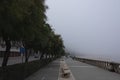 The cityscape is a walking bank along the ocean in heavy fog. Royalty Free Stock Photo