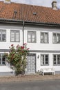 White traditional house with red rose flowers and bench on sidewalk , Helsingor, Denmark Royalty Free Stock Photo