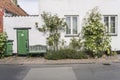 White traditional house with white rose flowers and bench on sidewalk , Helsingor, Denmark Royalty Free Stock Photo