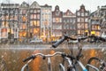 Cityscape - winter view from bicycles to houses with festive decorations and a city channel with boats, city of Amsterdam