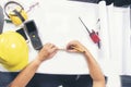 Civil construction engineer working with laptop at desk office with white yellow safety hard hat at office on construction site. Royalty Free Stock Photo