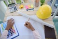 Civil construction engineer working with laptop at desk office with white yellow safety hard hat at office on construction site. Royalty Free Stock Photo