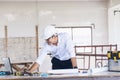 Civil construction engineer working with laptop at desk office with white yellow safety hard hat at office on construction site. Royalty Free Stock Photo