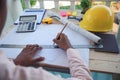 Civil construction engineer working with laptop at desk office with white yellow safety hard hat at office on construction site. Royalty Free Stock Photo