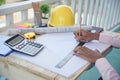 Civil construction engineer working with laptop at desk office with white yellow safety hard hat at office on construction site. Royalty Free Stock Photo