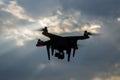 Civil drone in flight against the background of dramatic evening sky, surveillance and control from the air. Royalty Free Stock Photo