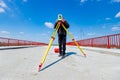 Civil engineer, geodesist is working with total station on a building site, unfinished bridge Royalty Free Stock Photo