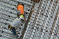 Civil engineer inspecting the work progress of a worker in a con