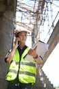 Civil engineer standing at construction site and having phone conversation Royalty Free Stock Photo