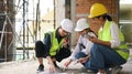 Civil engineer team and supervisor sitting in construction site floor and discussing on plan while visiting a new Royalty Free Stock Photo