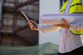 Civil engineer using a tablet, planning a project, builds a modern structure, reading a plan. Architect or engineer working on a Royalty Free Stock Photo