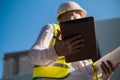 Civil engineer using a tablet, planning a project, builds a modern structure, reading a plan. Architect or engineer working on a Royalty Free Stock Photo