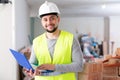 Civil engineer working on a construction site indoors monitors the process of capital repairs of a brick house on laptop