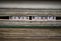 Civil rights restriction concept: Closeup of isolated antique old book pile text blocks and yellowed pages with wooden alphabet Royalty Free Stock Photo