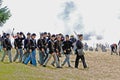 Civil War reenactors marching across a battlefield.