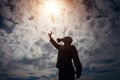 Civilian man in military gas mask raised his hand to sky. Loss ozone layer. Sun dangerous. Toxic air. Human silhouette in a gas