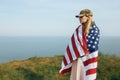 Civilian woman in her husband`s military cap. A widow with a flag of the united states left without her husband. Memorial Day to