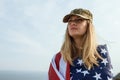 Civilian woman in her husband`s military cap. A widow with a flag of the united states left without her husband. Memorial Day to