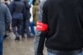 civillian man with red armband signed people& x27;s squad in russian - standing in crowd, close-up with selective focus