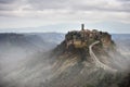 Civita di Bagnoregio, Lazio, Italy: picturesque landscape at dawn of the ancient village shrouded in fog on the steep tuff hill Royalty Free Stock Photo