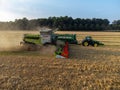 Claas 8900 harvester combine offloading to tractor in the field in Faxe, Denmark Royalty Free Stock Photo