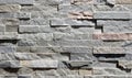 Cladding wall made of small uneven stone bricks, predominantly gray.