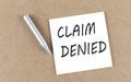 CLAIM DENIED text on sticky note on a cork board with pencil Royalty Free Stock Photo