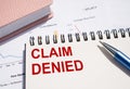 CLAIM DENIED. Text written on notepad with pen on financial documents Royalty Free Stock Photo