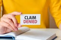 Claim denied written on a paper card in woman hand, concept Royalty Free Stock Photo