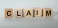 Claim word on wooden cube on gray background