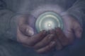 Clairvoyance. A fortune teller, an oracle holds a magic sphere in her hands to see the future. A magical bright glowing ball lies Royalty Free Stock Photo