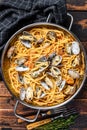 Clams vongole Seafood pasta Spaghetti in a pan. Dark Wooden background. Top view